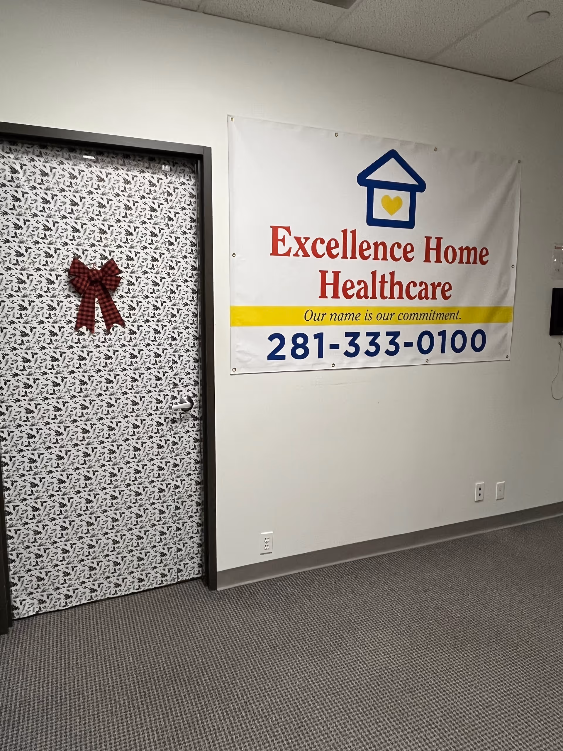 Indoor hallway with a patterned door and banner reading Excellence Home Healthcare.