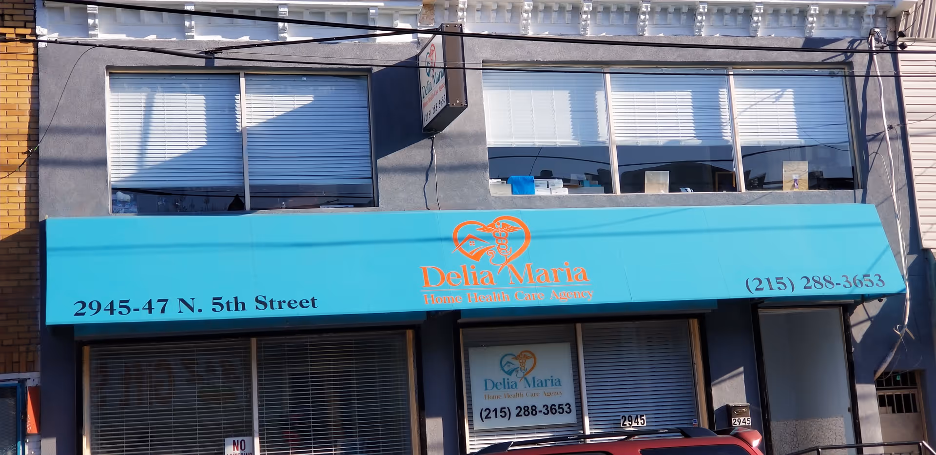 Blue storefront awning with Delia Maria Home Health Care Agency sign and street address.