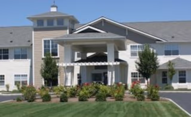 Exterior view of Jenny's Place senior living facility with entrance and landscaped front yard.