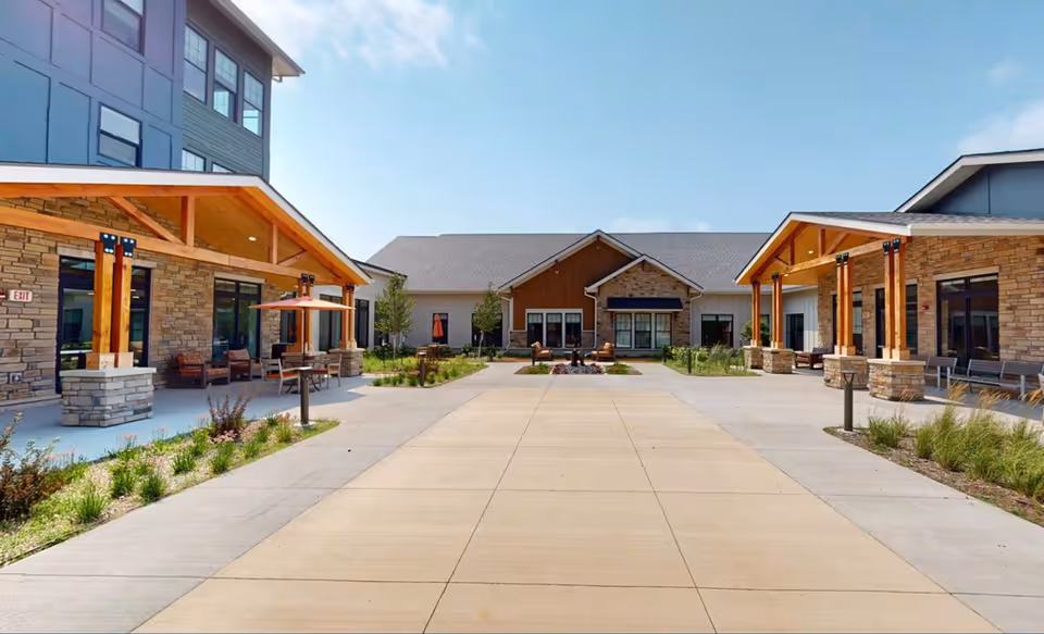 Exterior courtyard of CopperWood Senior Living at Prairie Trail with covered porches and seating.