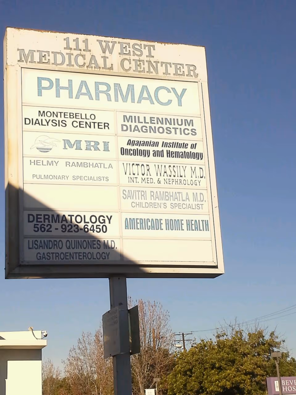 Tall outdoor signboard listing medical services including Pharmacy and AMERICADE HOME HEALTH.