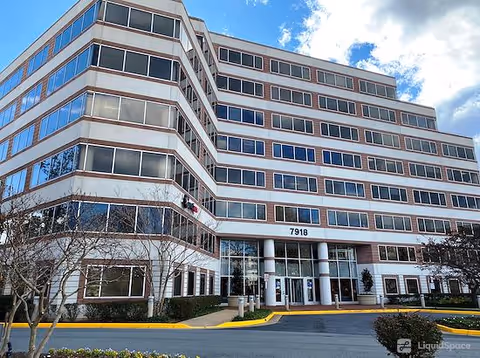 A multi-story senior living building with numerous windows and a covered front entrance.