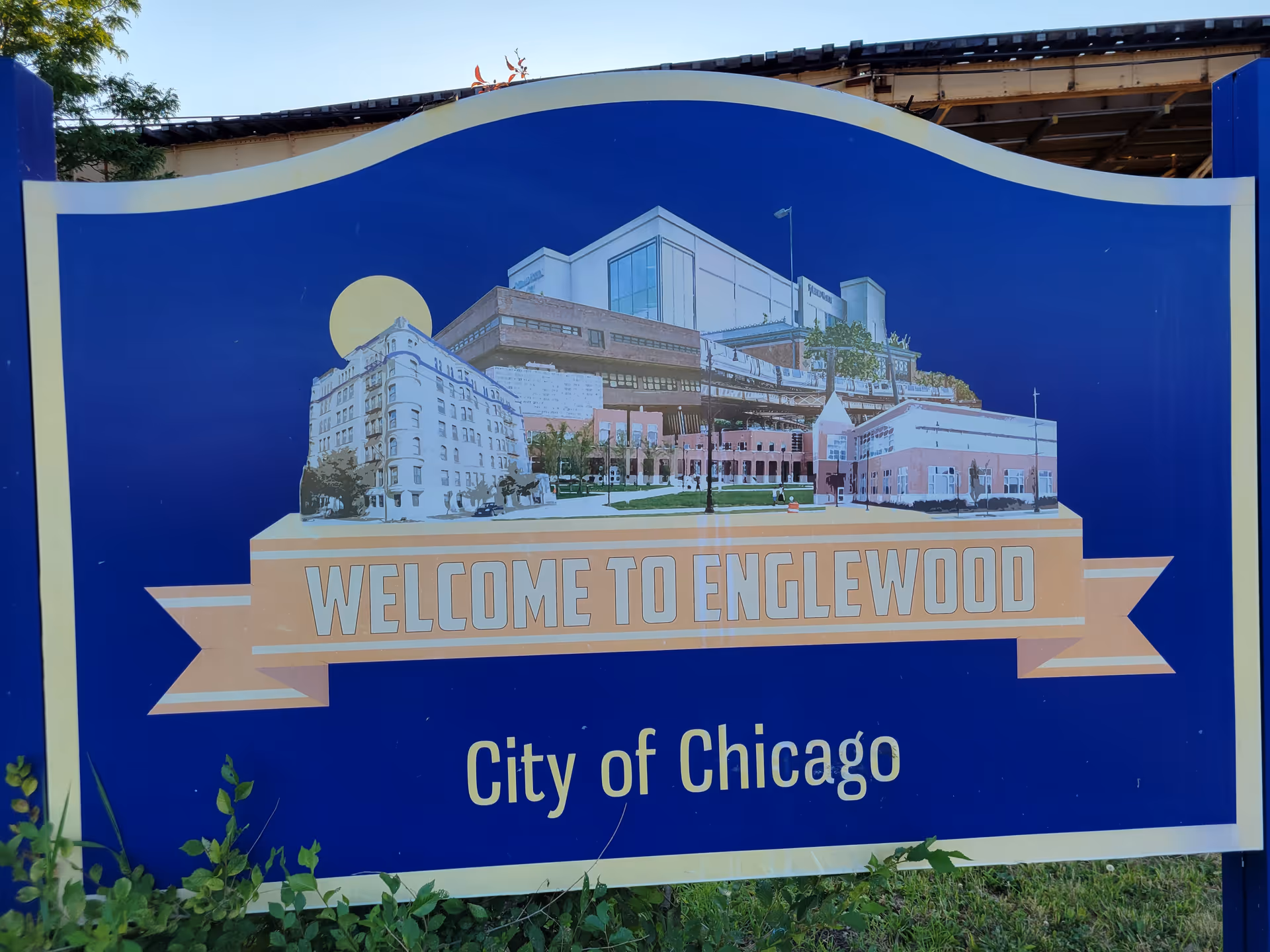 Blue outdoor sign reading Welcome to Englewood with a building collage, City of Chicago.