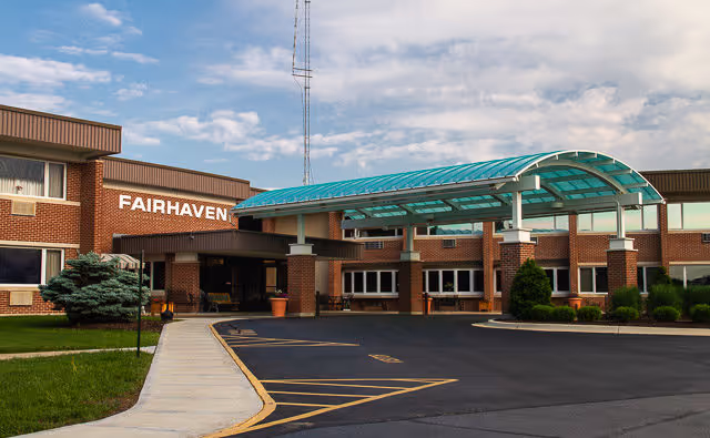 Front entrance of a brick nursing home with a covered glass canopy and a 'FAIRHAVEN' sign.