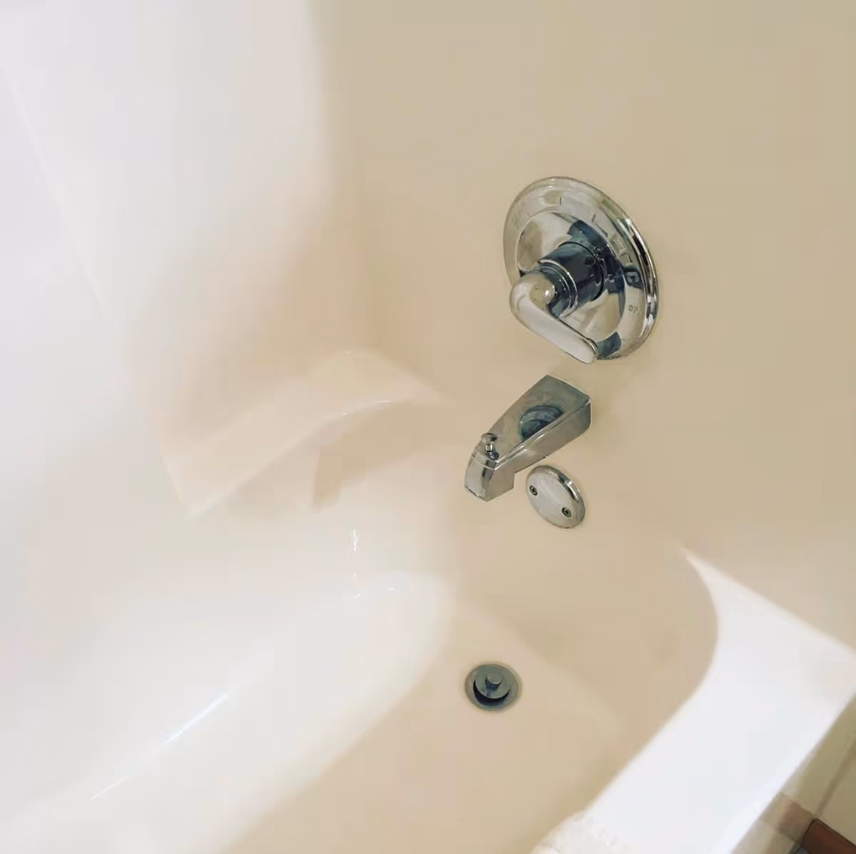 Close-up of a white bathtub with chrome faucet and shower control.
