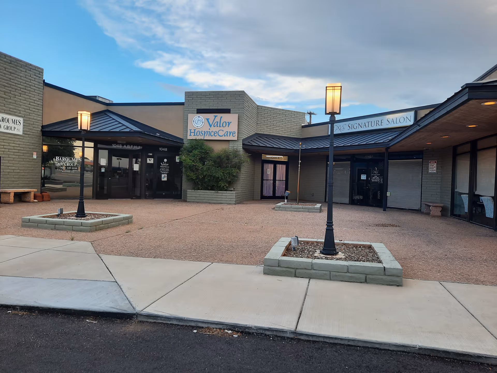 Exterior view of a plaza-style facility with Valor HospiceCare sign and storefronts.