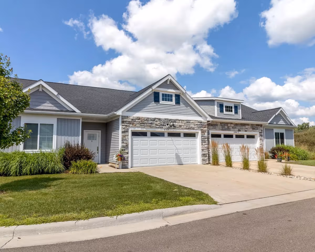 Exterior of StoryPoint Abbot Park with garages, stone accents, and landscaped frontage.