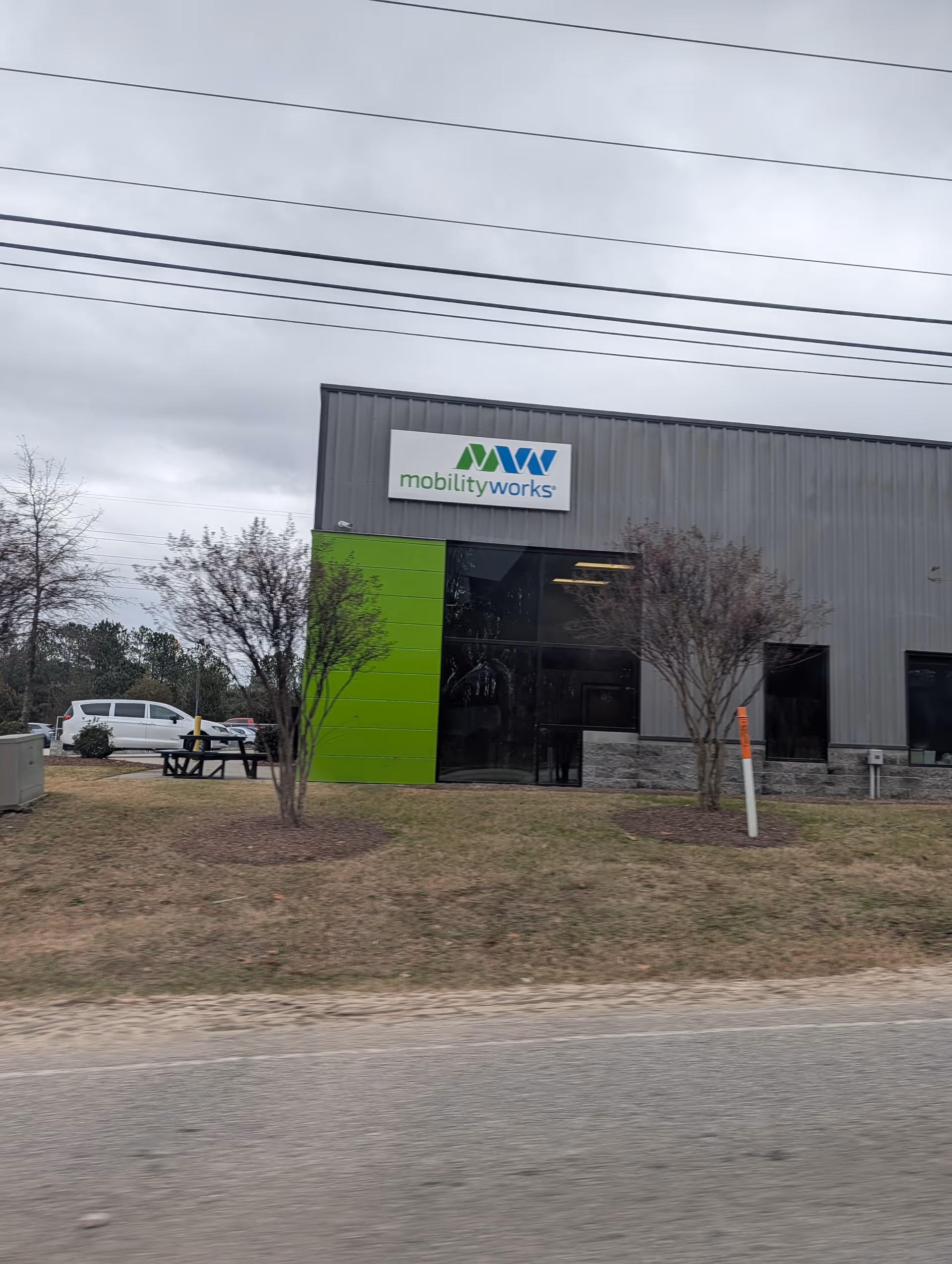 Exterior view of MobilityWorks building with a green wall and sign