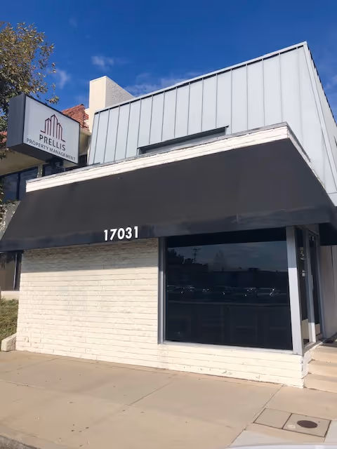 Exterior view of a storefront with a black awning and the number 17031.