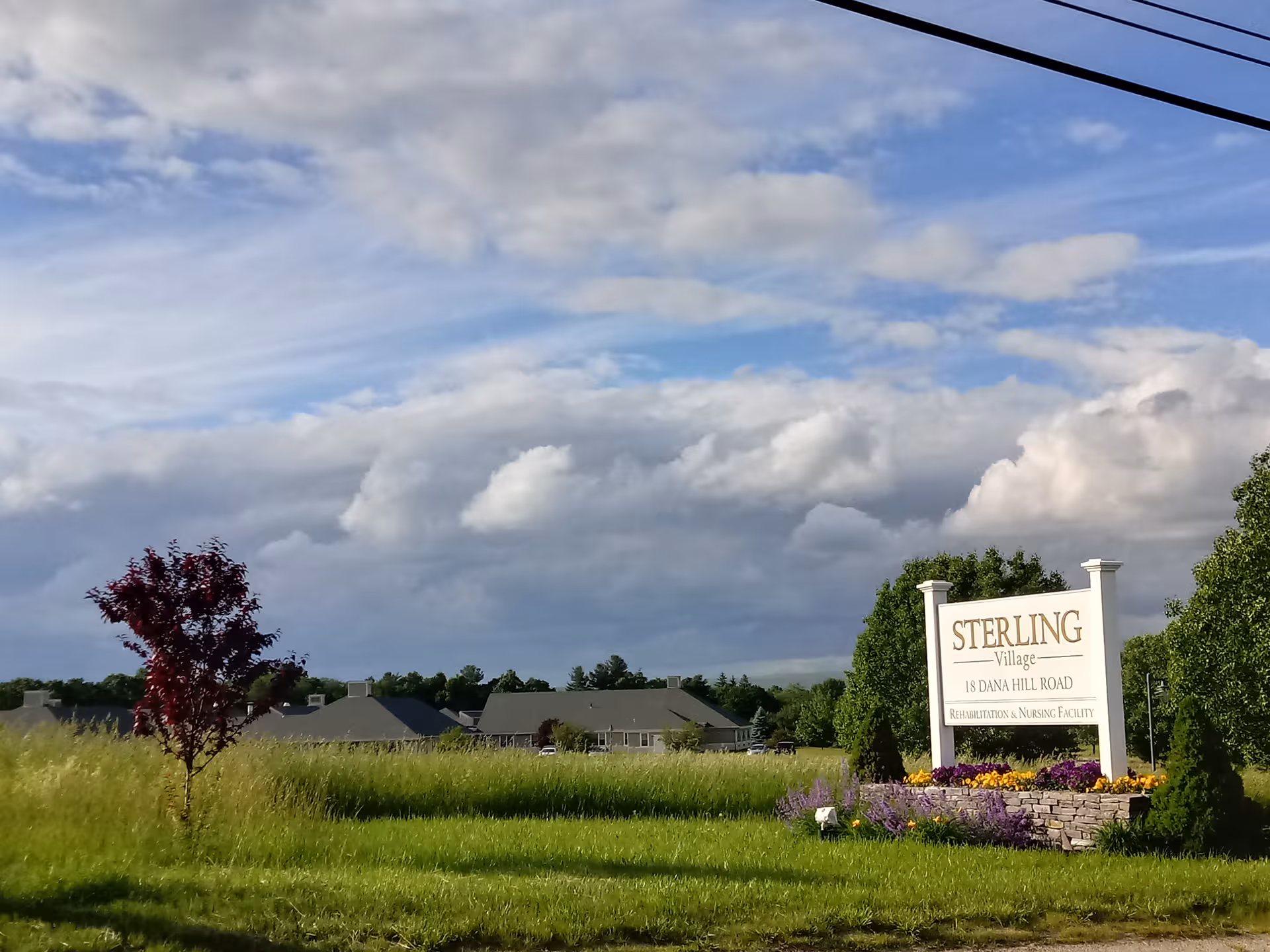 Exterior view of Sterling Village entrance sign with landscaped grounds.