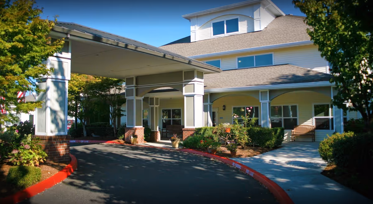 Facade of Prestige Senior Living Bridgewood with a covered entrance and landscaping.