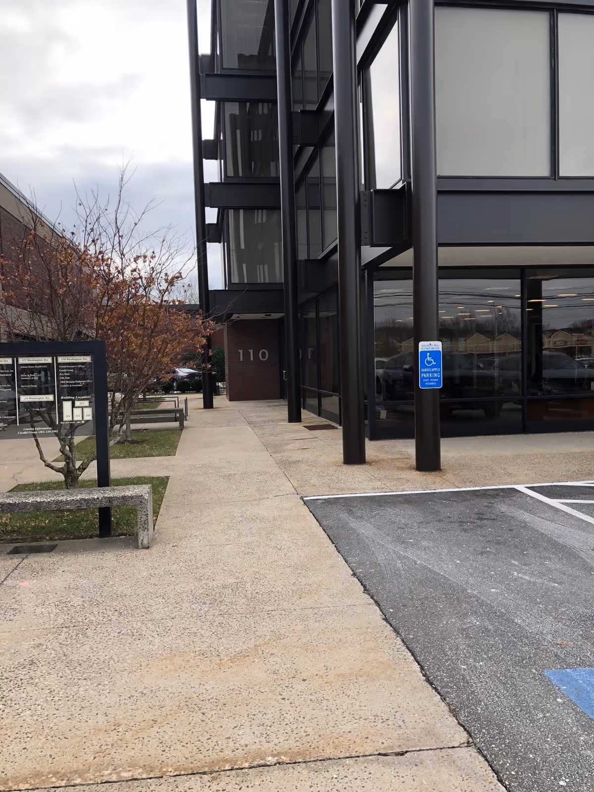 Exterior view of Compassionate Care At Home facility with glass entrance and sidewalk.