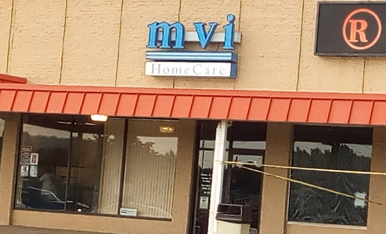 Exterior view of MVI HomeCare storefront with red awning and glass entrance.