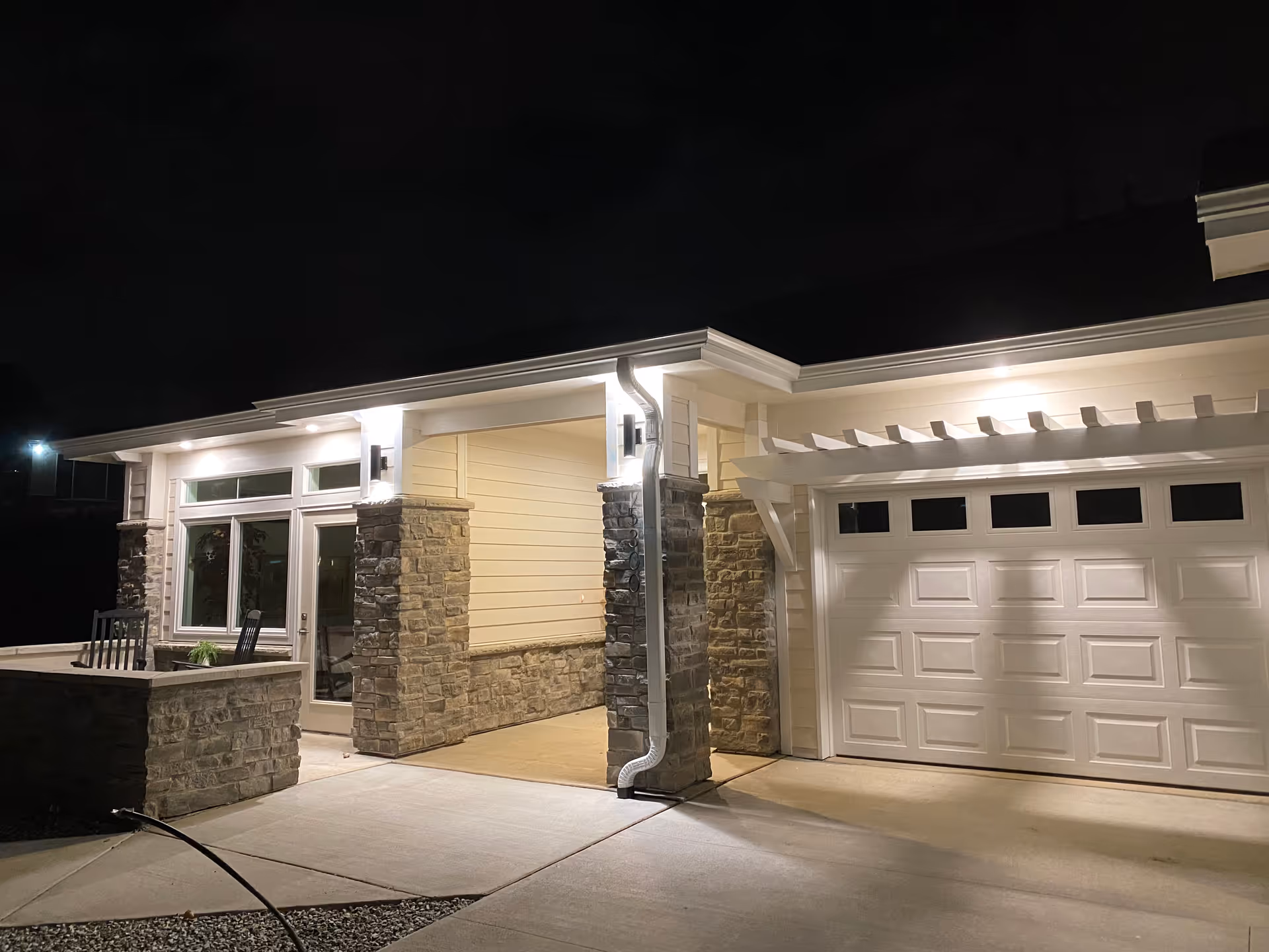 Night view of a modern senior living facility's front entrance with stone pillars.