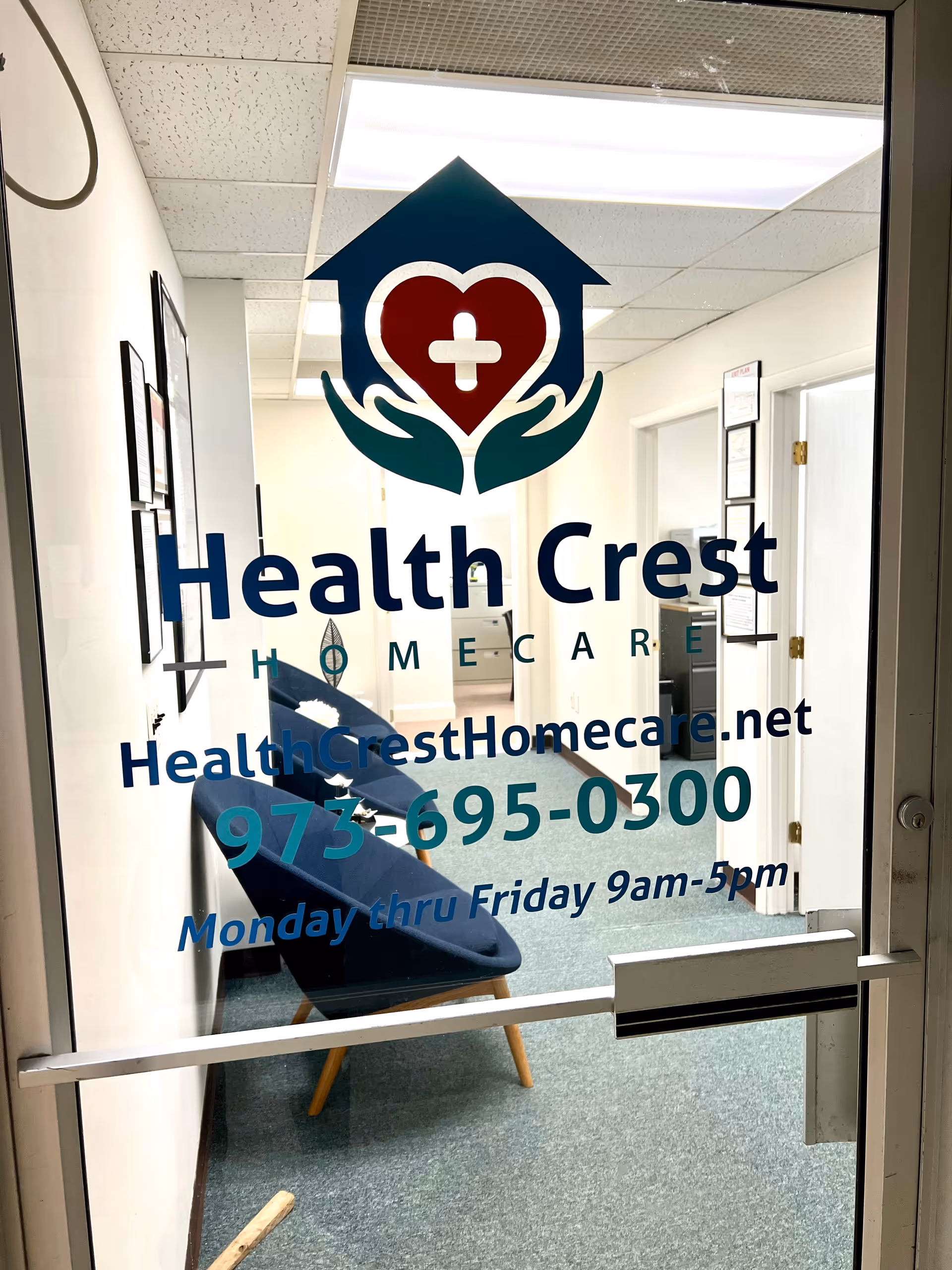 Glass entry door displays Health Crest Homecare logo and contact text in an interior hallway.
