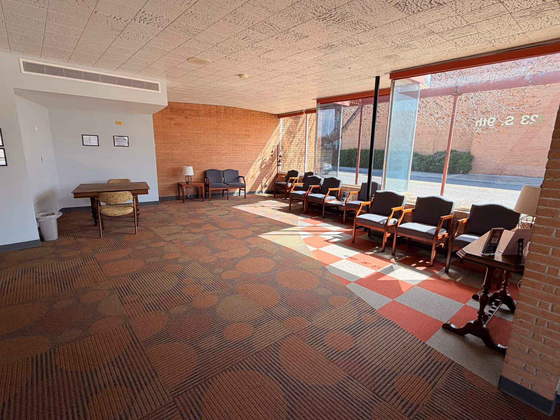 Spacious interior Strive lounge with row of chairs along large glass windows.