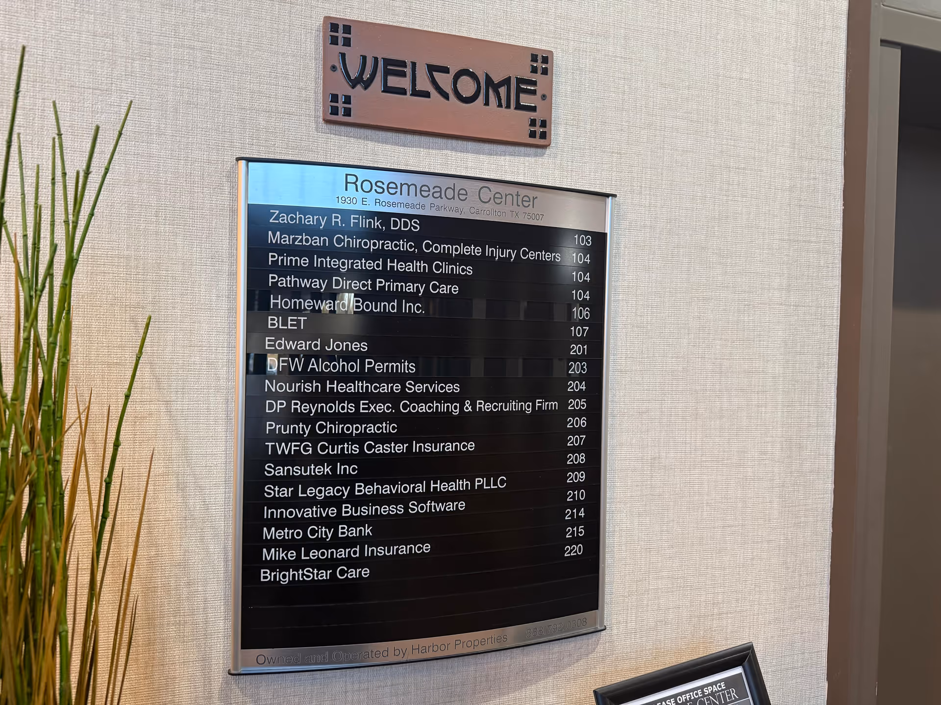 Interior wall with a welcome sign and a directory listing offices.