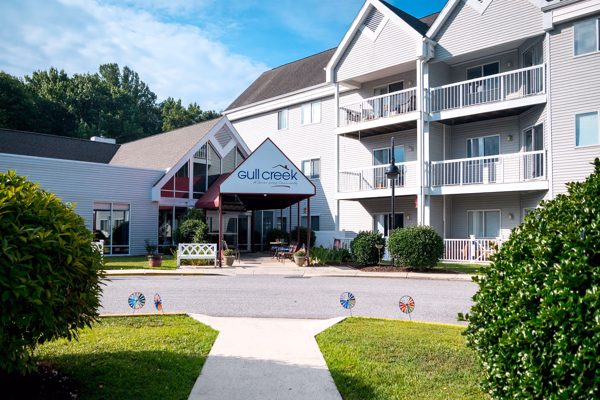 Exterior view of Gull Creek senior living facility with entrance and balconies.