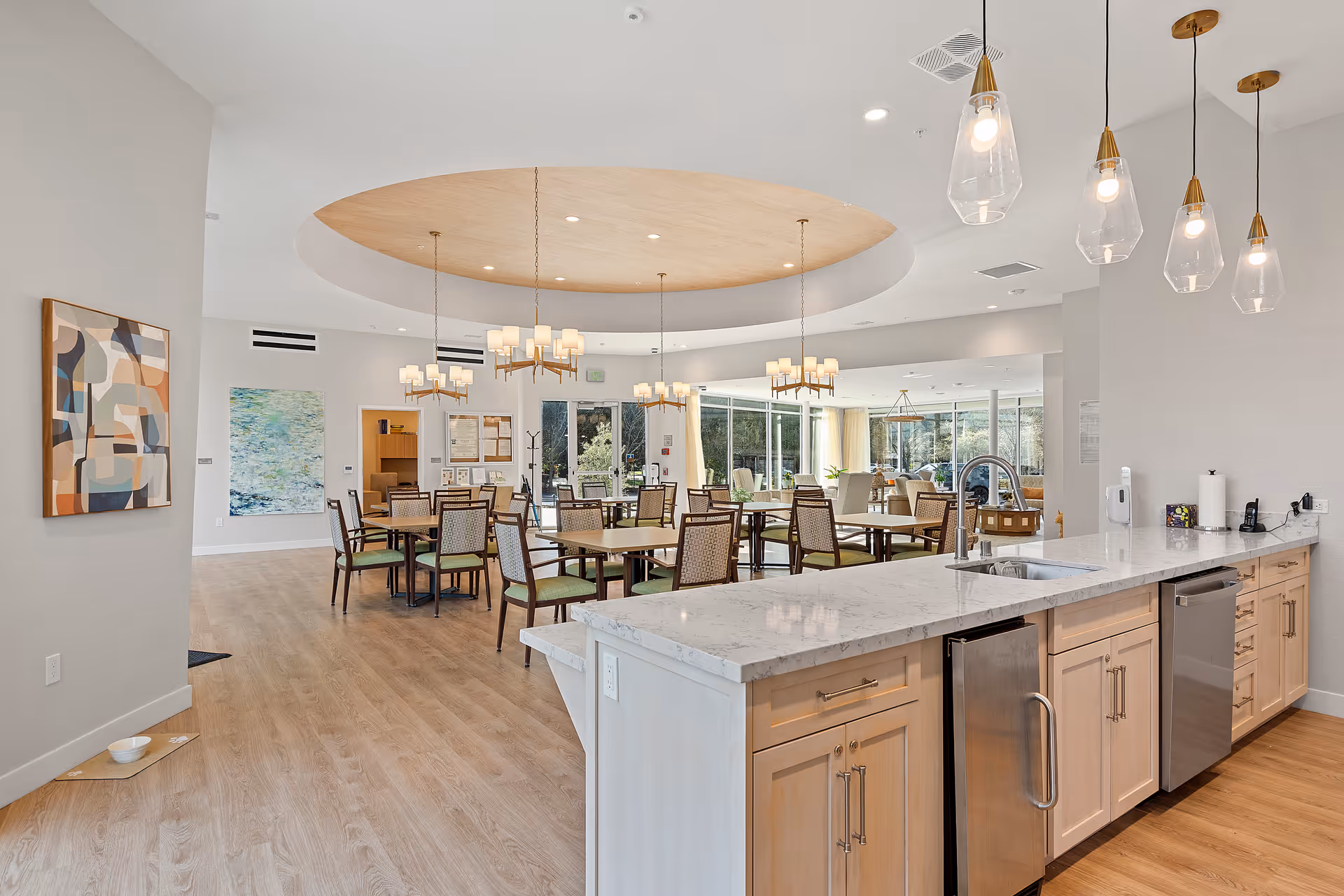 Aroha Memory Care communal dining area with kitchen island and pendant lights.