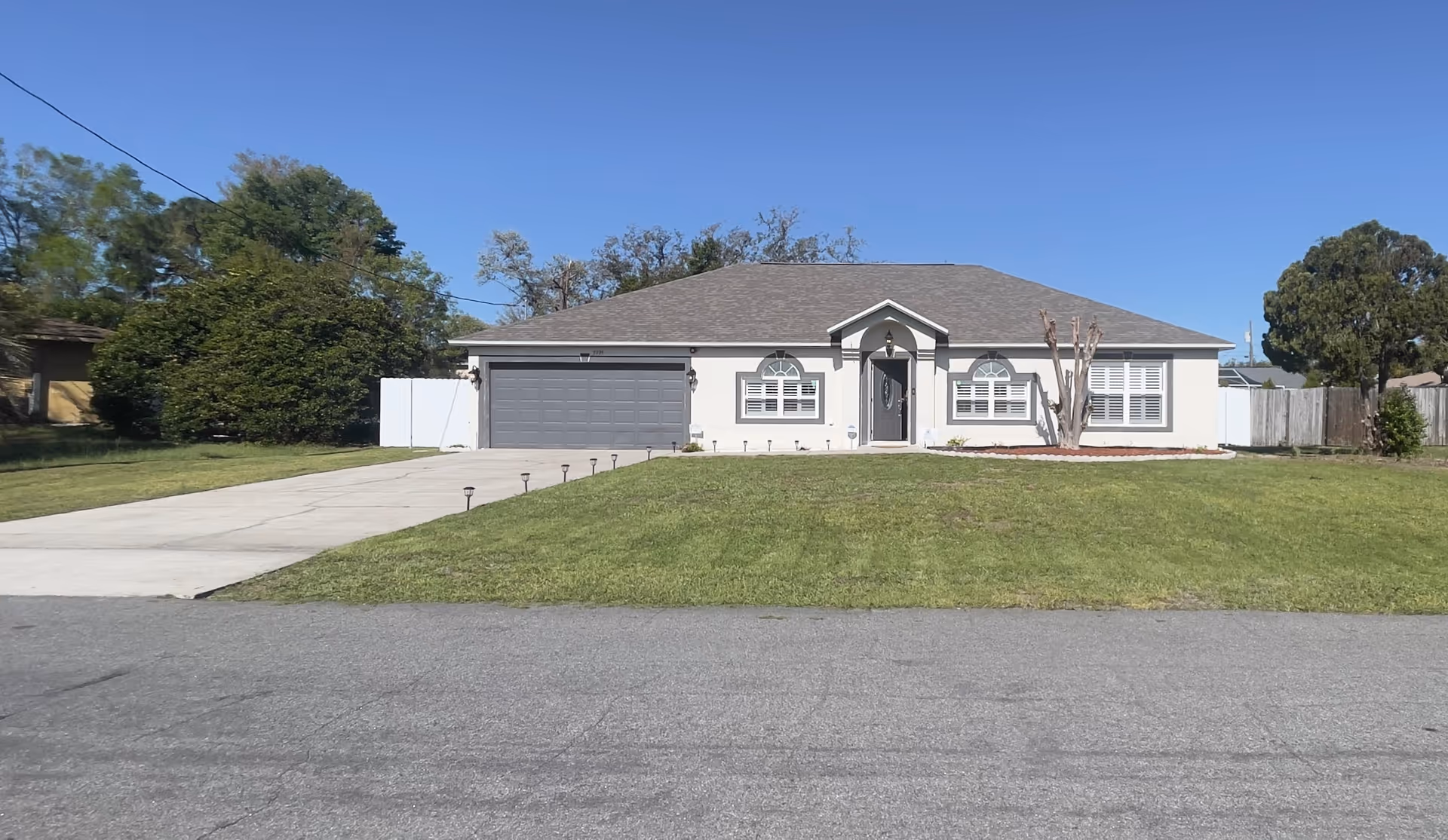 Front view of a single-story house with a two-car garage and lawn.