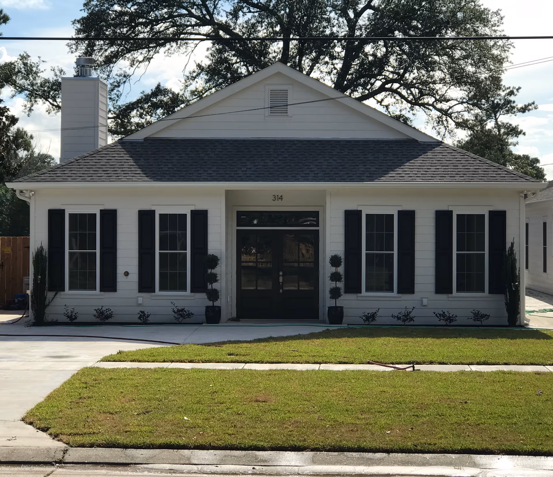 Front view of St. Michael's Assisted Living building with white exterior and black shutters.