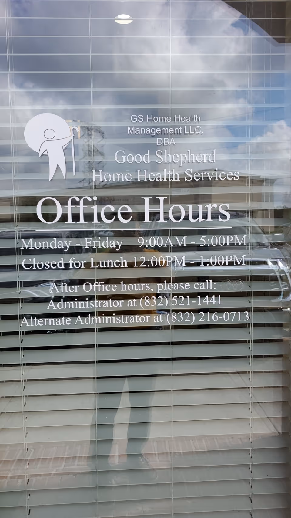 Glass door with Good Shepherd Home Health Services office hours text and blinds reflected