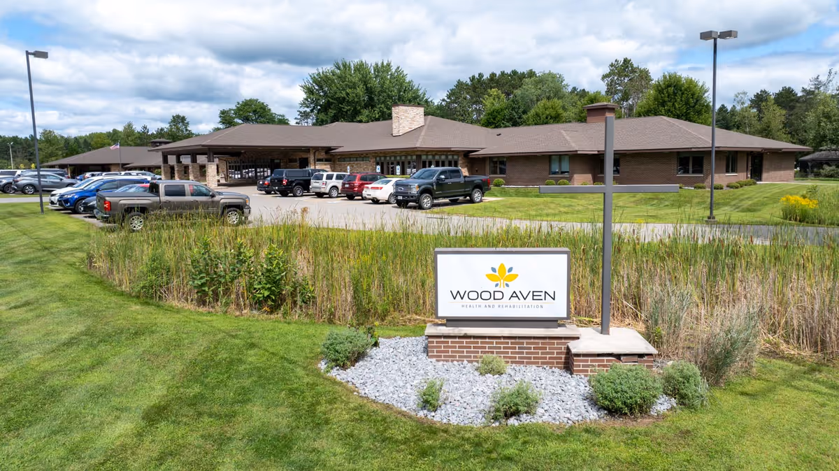 Single-story brick senior living facility with parking and landscaped entrance.