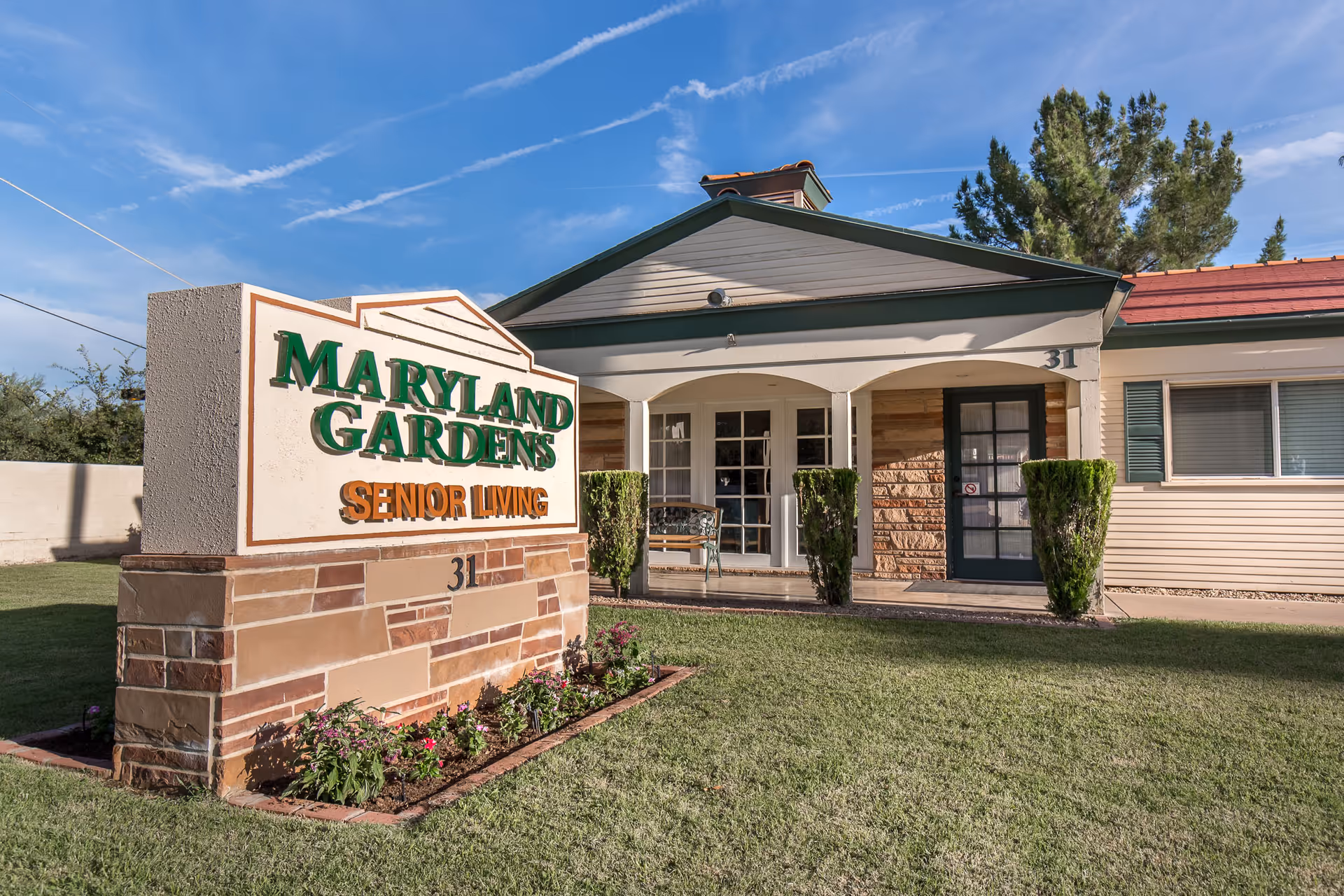 Front view of Maryland Gardens Senior Living with sign and entrance.