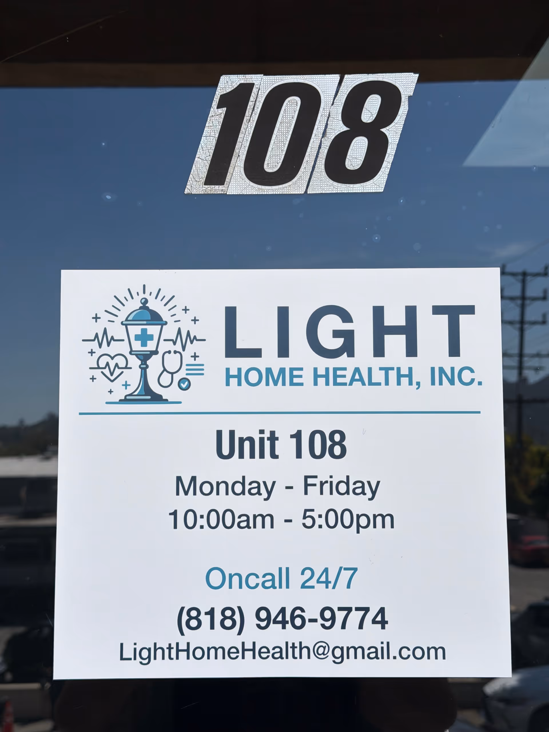 Glass door displays '108' above a Light Home Health unit sign with hours.