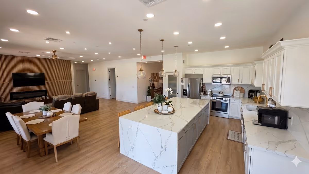 Open-concept living area with marble kitchen island, dining table, and lounge seating.