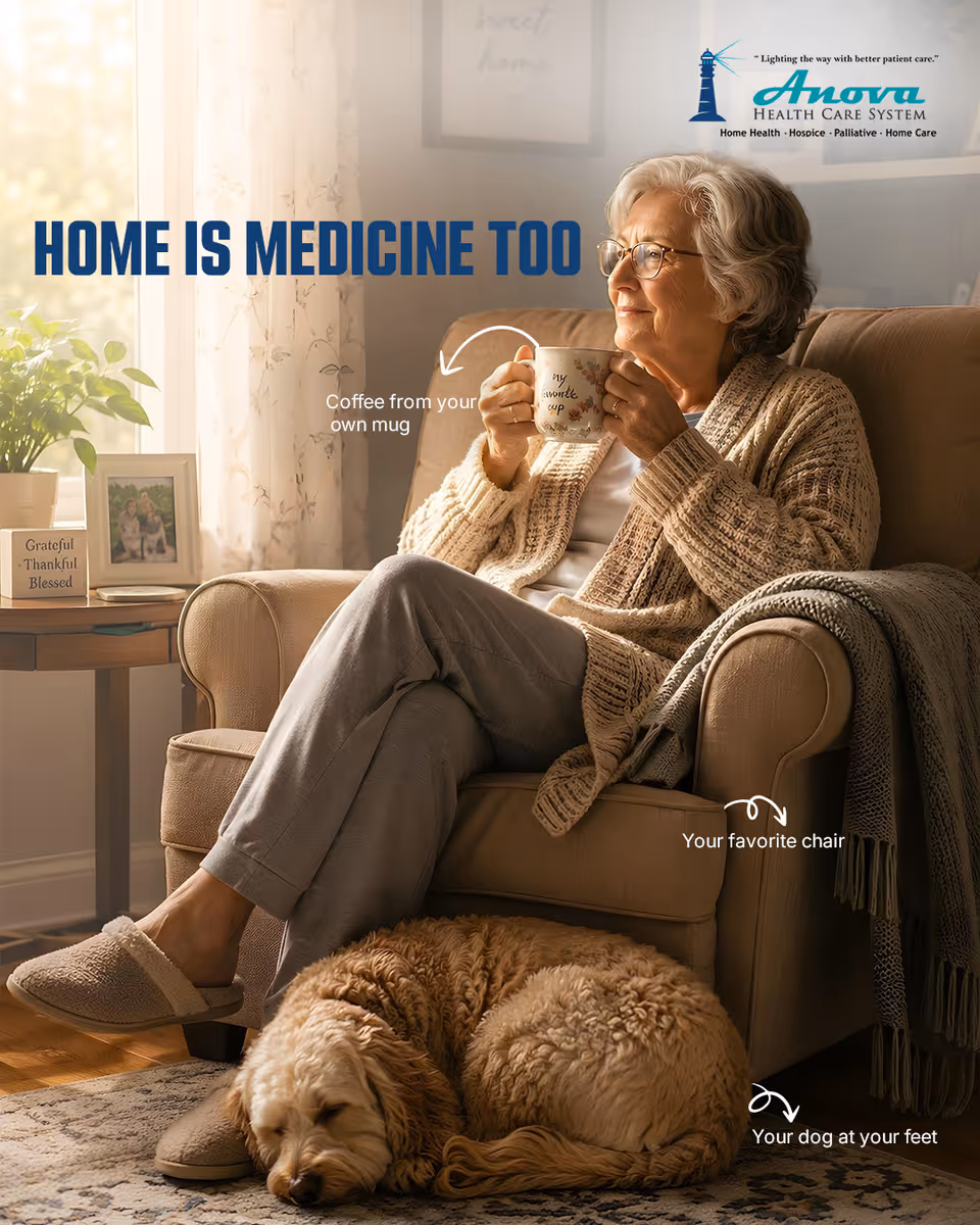 Elderly woman sits comfortably in a living room holding a mug, with a dog resting nearby.
