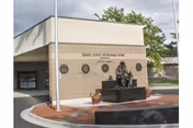Front exterior of Idaho State Veterans Home Lewiston with a statue in front.