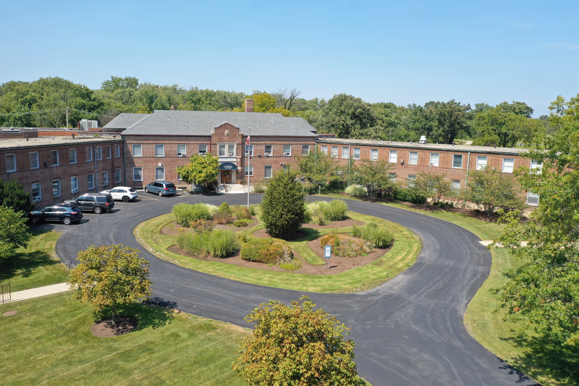 Exterior of Cantata Adult Life Services facility with circular driveway and landscaped center island.