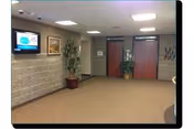 Interior lobby at Ohau Sholom Apartments with brick walls, carpet, TV, and potted plants