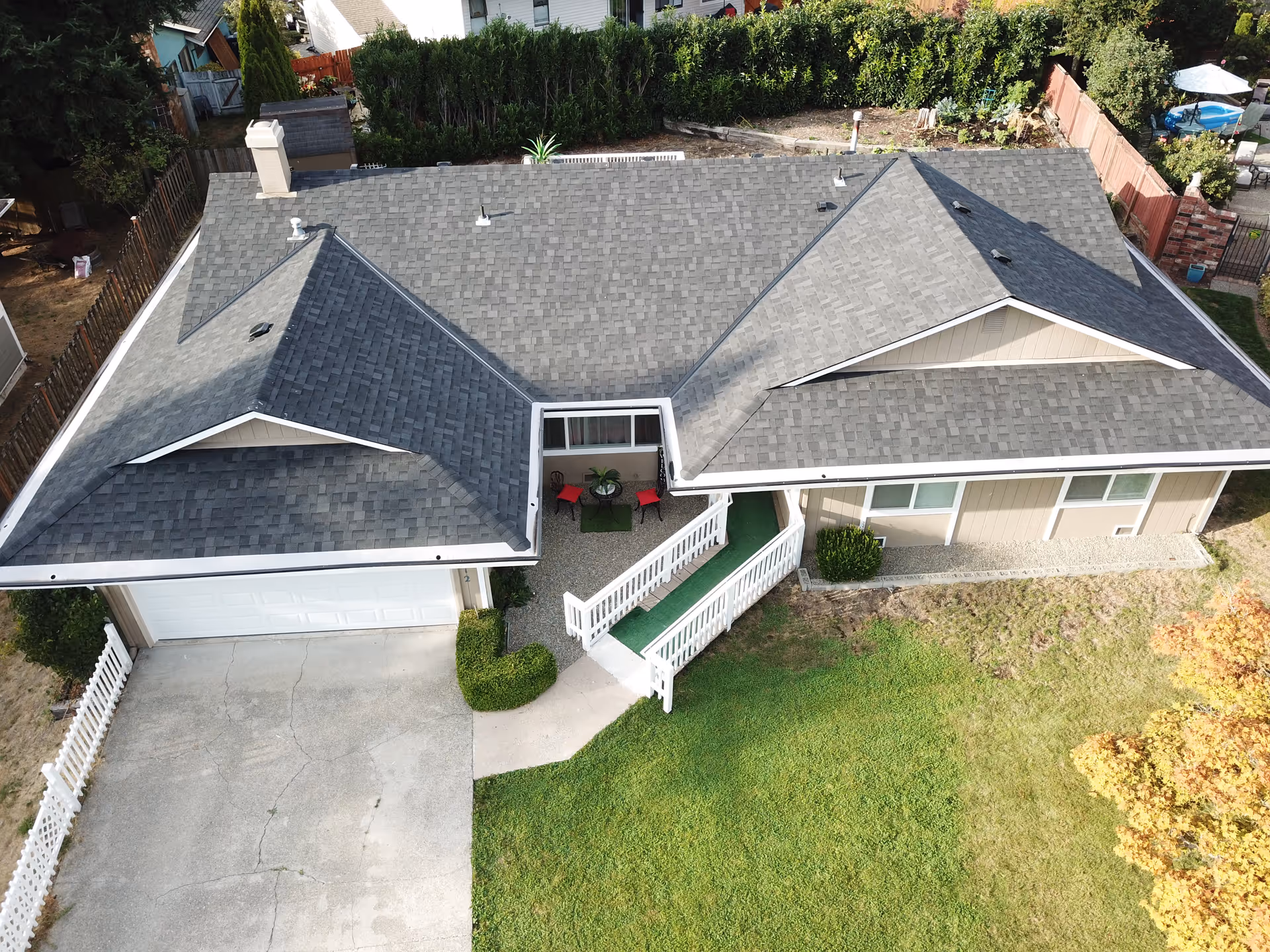 Aerial view of a single-story senior living home with a gray roof and a green lawn.