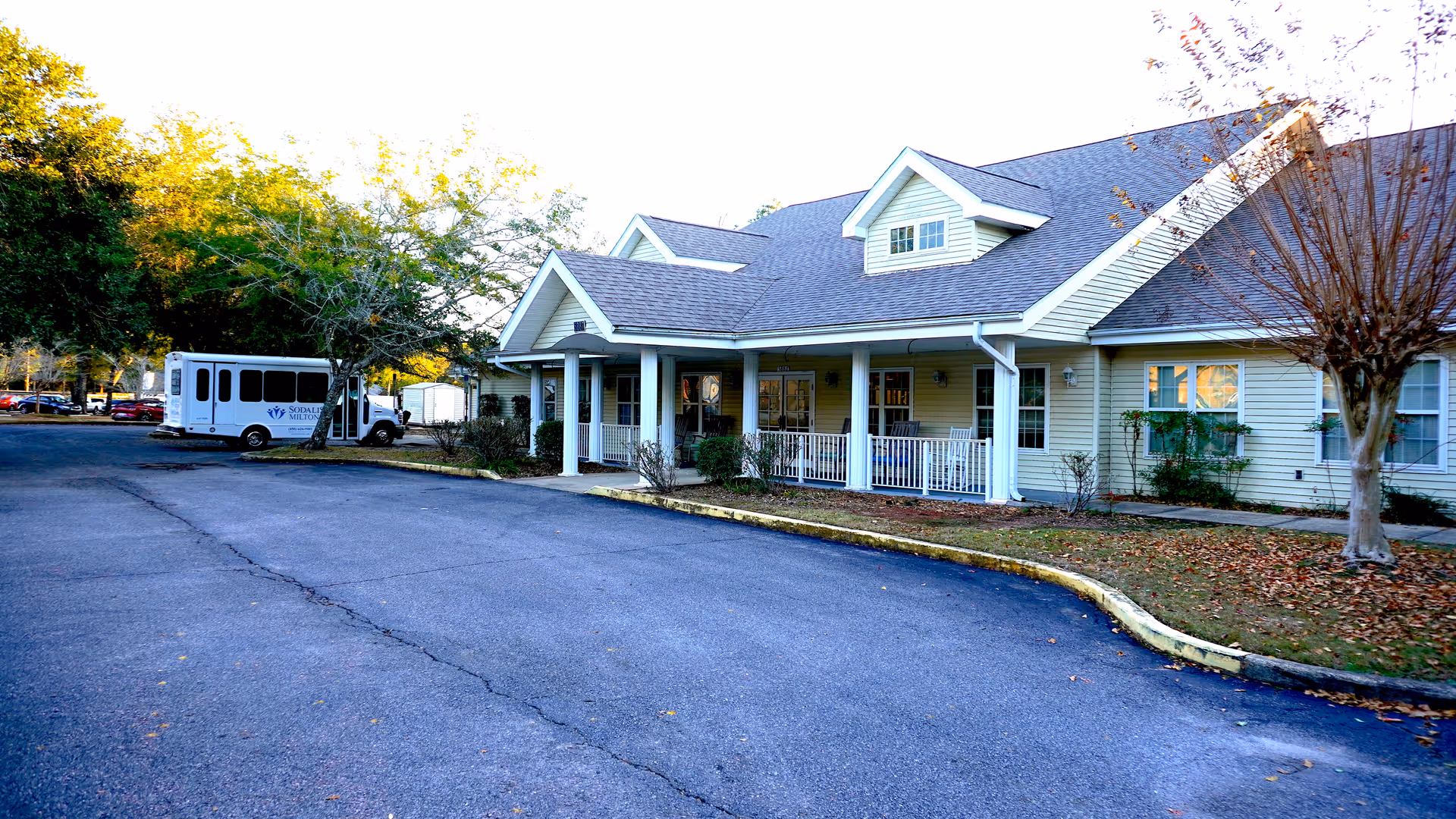 Exterior view of a single-story Sodalis Milton senior living facility with a front porch and parking.