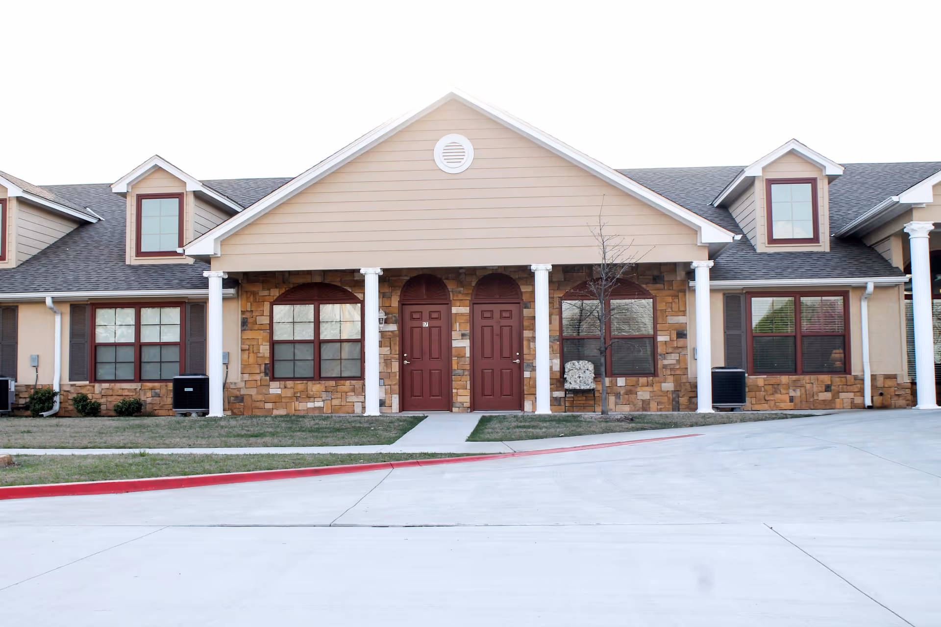 Exterior view of Silver Elm Estates Norman with front entrance and stone facade.