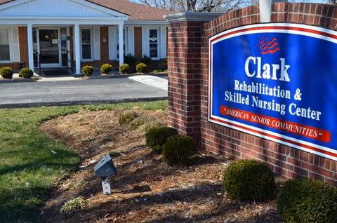 Exterior view of Clark Rehabilitation and Skilled Nursing Center with brick sign and entrance.