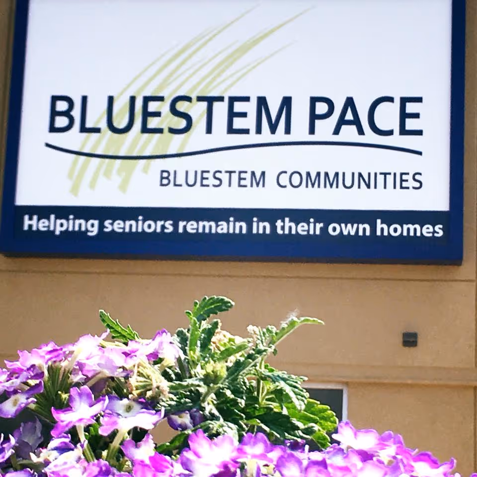 Exterior view of Bluestem PACE sign with purple flowers in foreground.