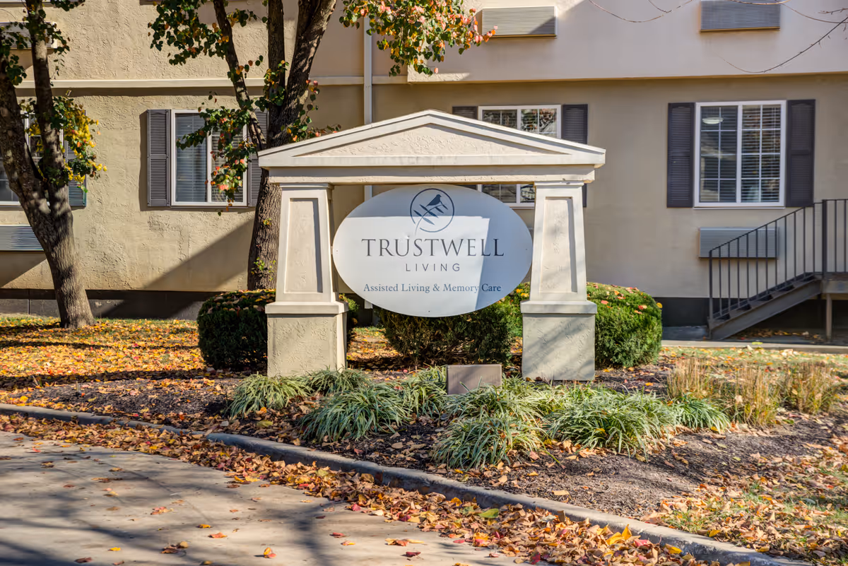 Front exterior view of a senior living building with a circular Trustwell Living sign.