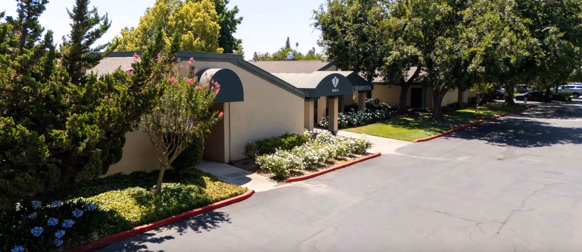 Exterior of Vintage Faire Residential senior living facility with entrance arches and landscaped parking area.