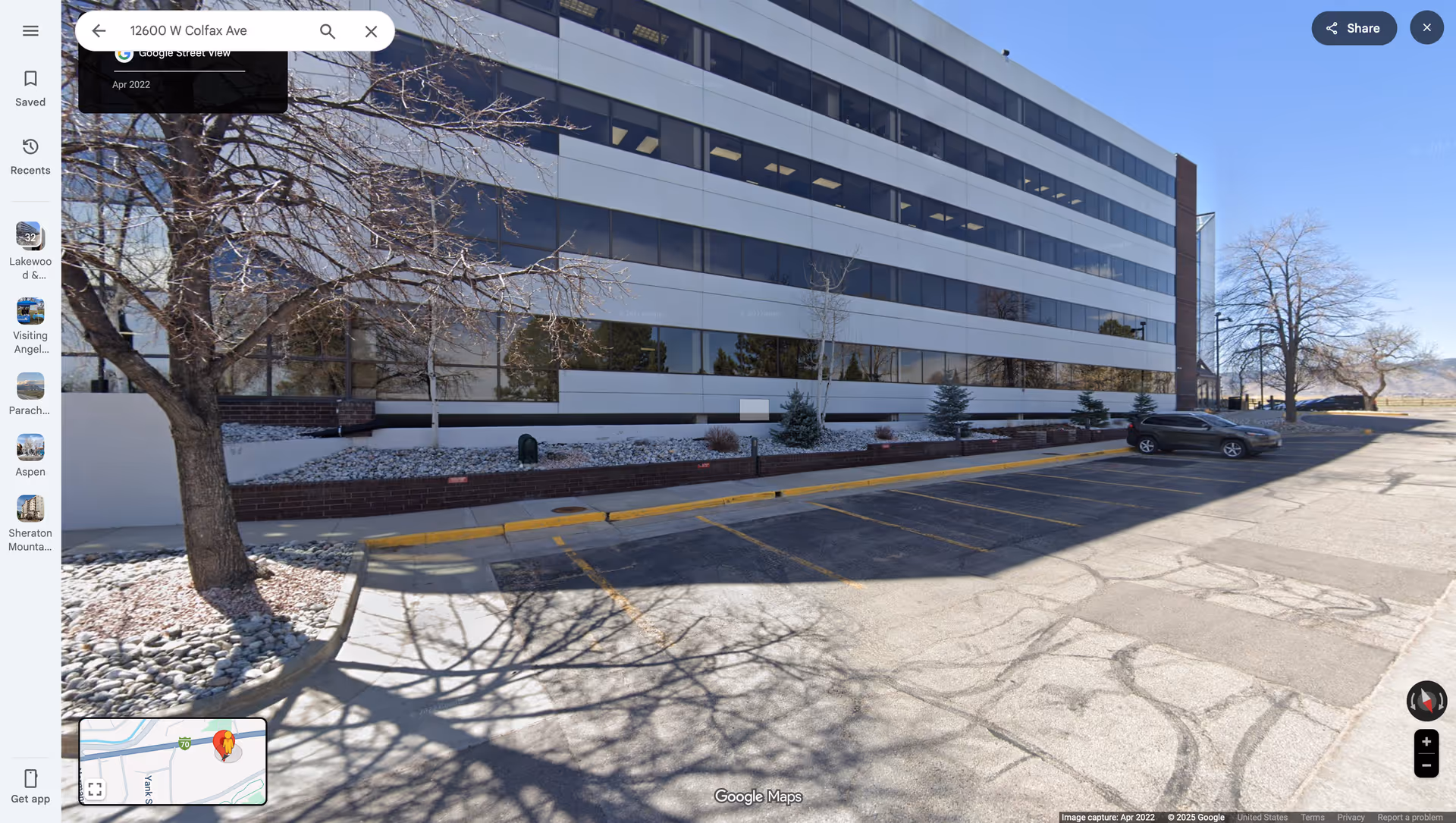 Exterior view of a modern office-style building with a snow-dusted parking lot and trees