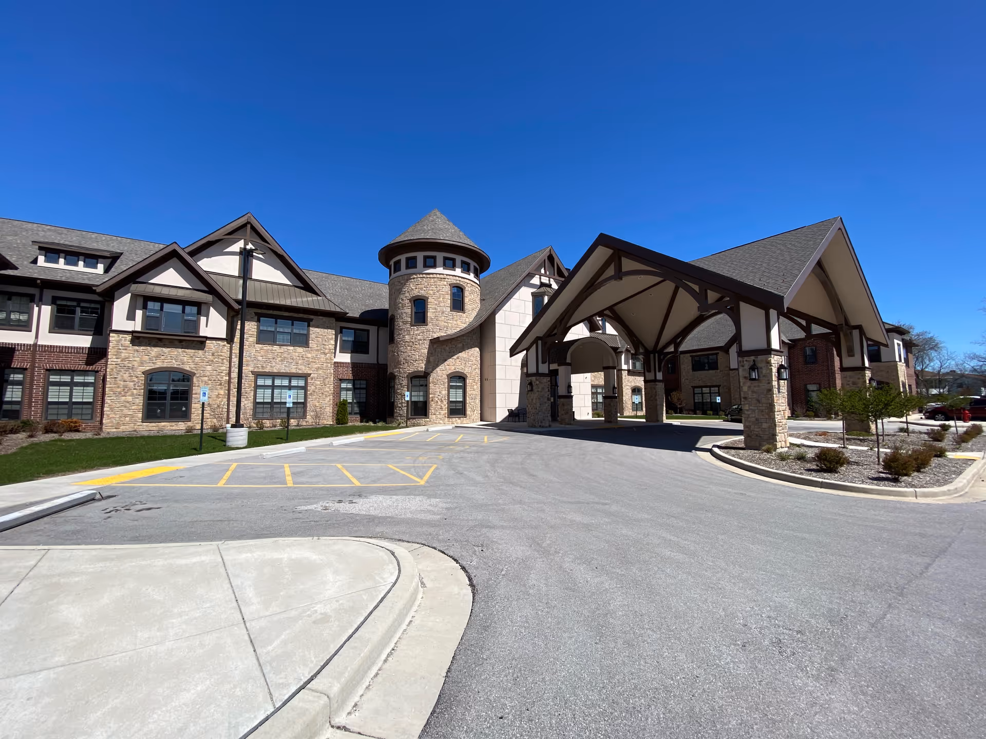 Discovery Commons Brookfield senior living building with a stone facade and covered entrance driveway