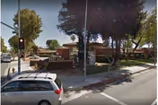 Exterior view of West Hills Health and Rehab Center with trees and cars nearby.
