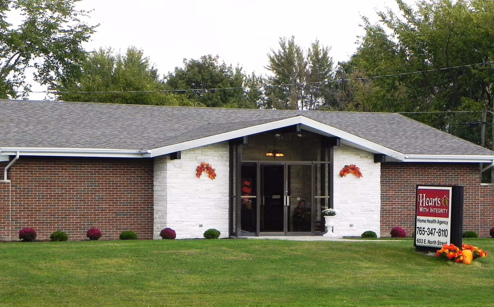 Front view of Hearts With Integrity Home Health Agency building with sign and lawn.
