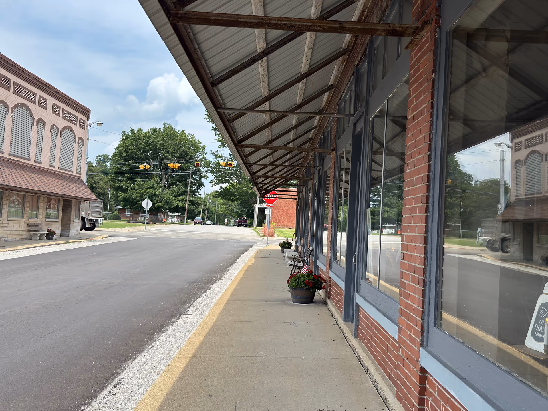 Street view of a brick storefront with large windows and an awning.