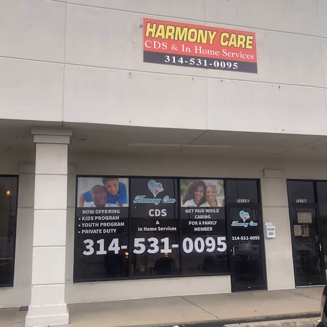 Exterior view of Harmony Care facility with signage and window advertisements.