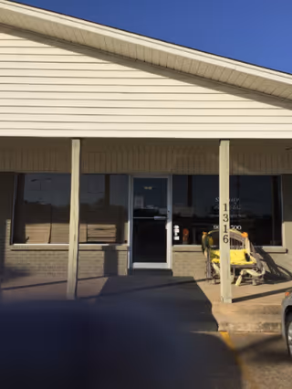 Front entrance of a single-story hospice facility with glass doors.