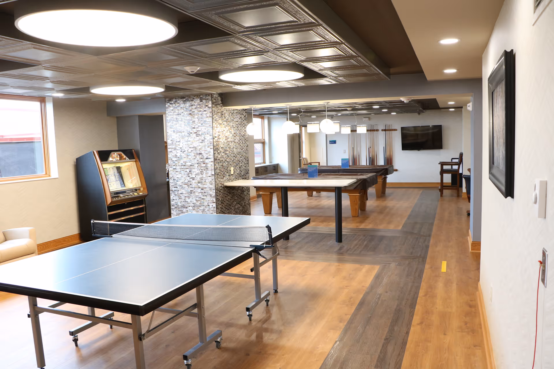 Interior recreation room at Charter House with ping-pong table, pool tables, and seating.
