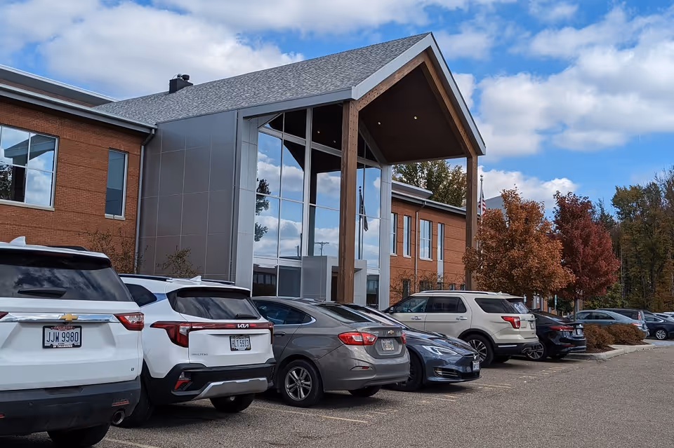 Exterior view of Absolute Home Health building with a glass front entrance and parked cars.